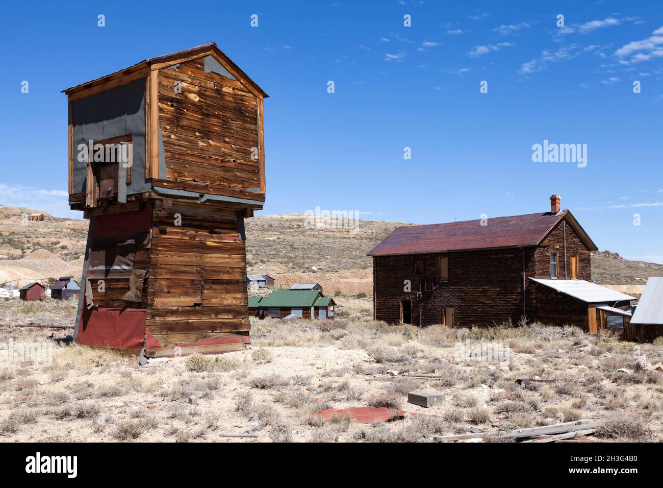 A water tower and railroad depot stand atop the hill east of the ghost town of Bodie in Bodie Historical Park. Stock Photo
