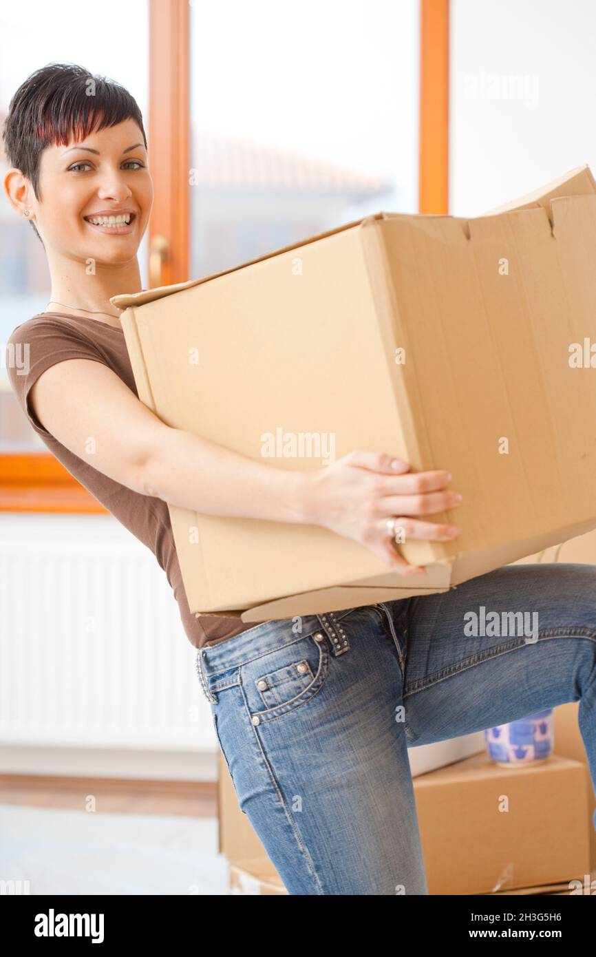 Young woman lifting cardboard box Stock Photo - Alamy