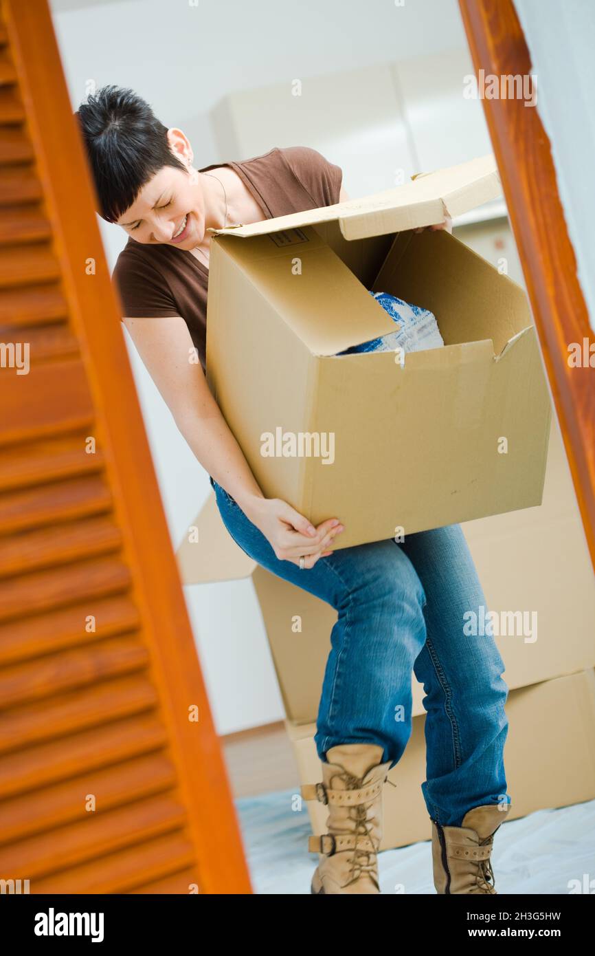 Young woman lifting cardboard box Stock Photo - Alamy