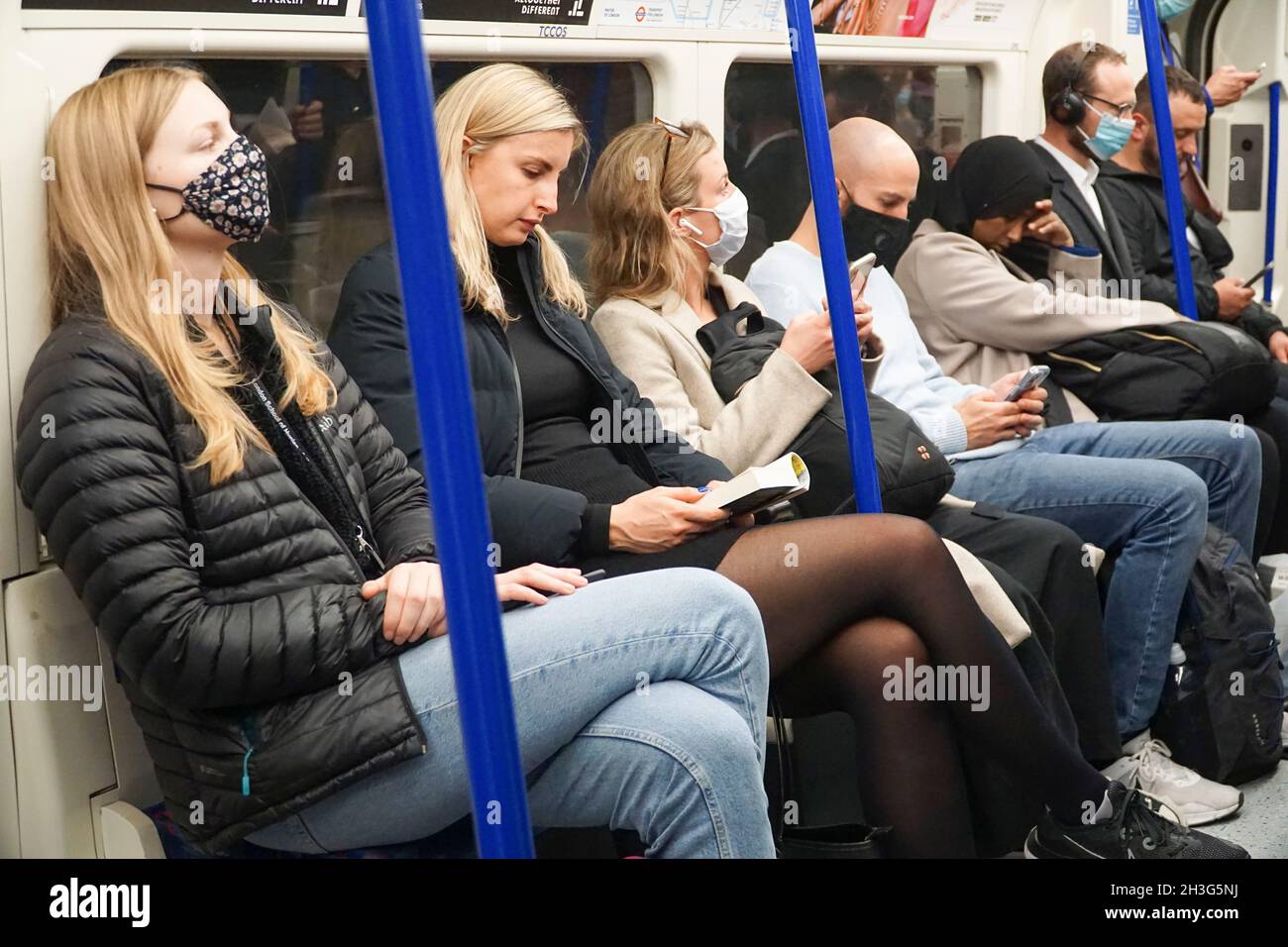 London, UK, 28 October 2021: On the London Underground some people wear face masks but not all do. Although a mask is not required if a person has a medical exemption, large numbers of passengers are travelling without masks despite very high levels of coronavirus transmission and new covid-19 cases. Anna Watson/Alamy Live News Stock Photo