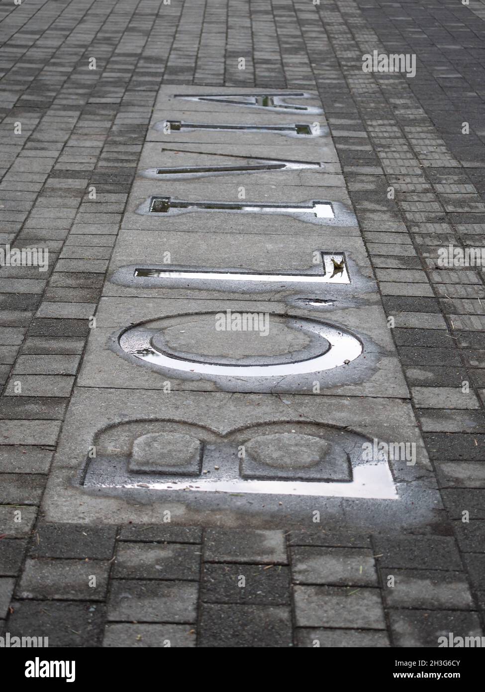 Bolivia, Country Name Written in Large Letters on a Wet Cement Floor in a Public Park Stock Photo