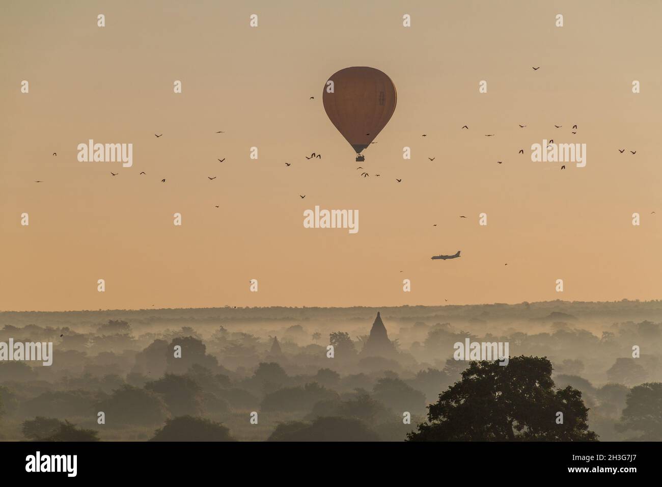 Balloon over Bagan, landing airplane and the skyline of its temples, Myanmar Stock Photo