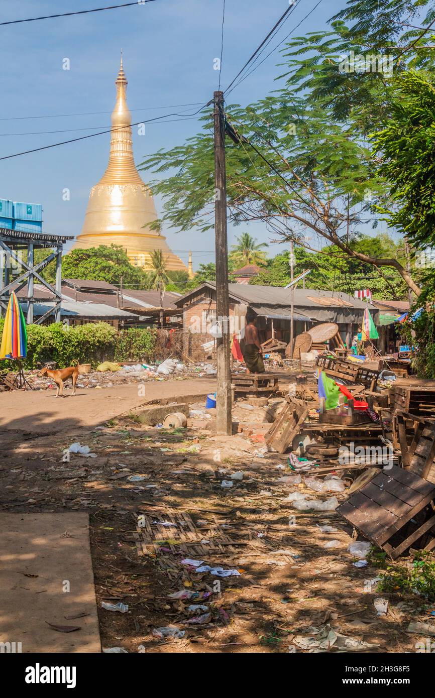 BAGO, MYANMAR - DECEMBER 10, 2016: Dirty residential area and Shwemawdaw Pagoda in Bago. Stock Photo