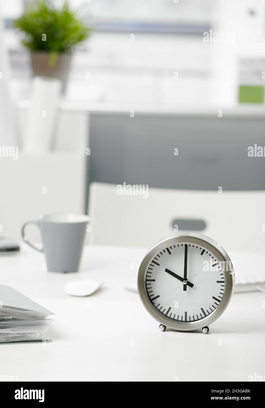 Clock on office desk Stock Photo Alamy