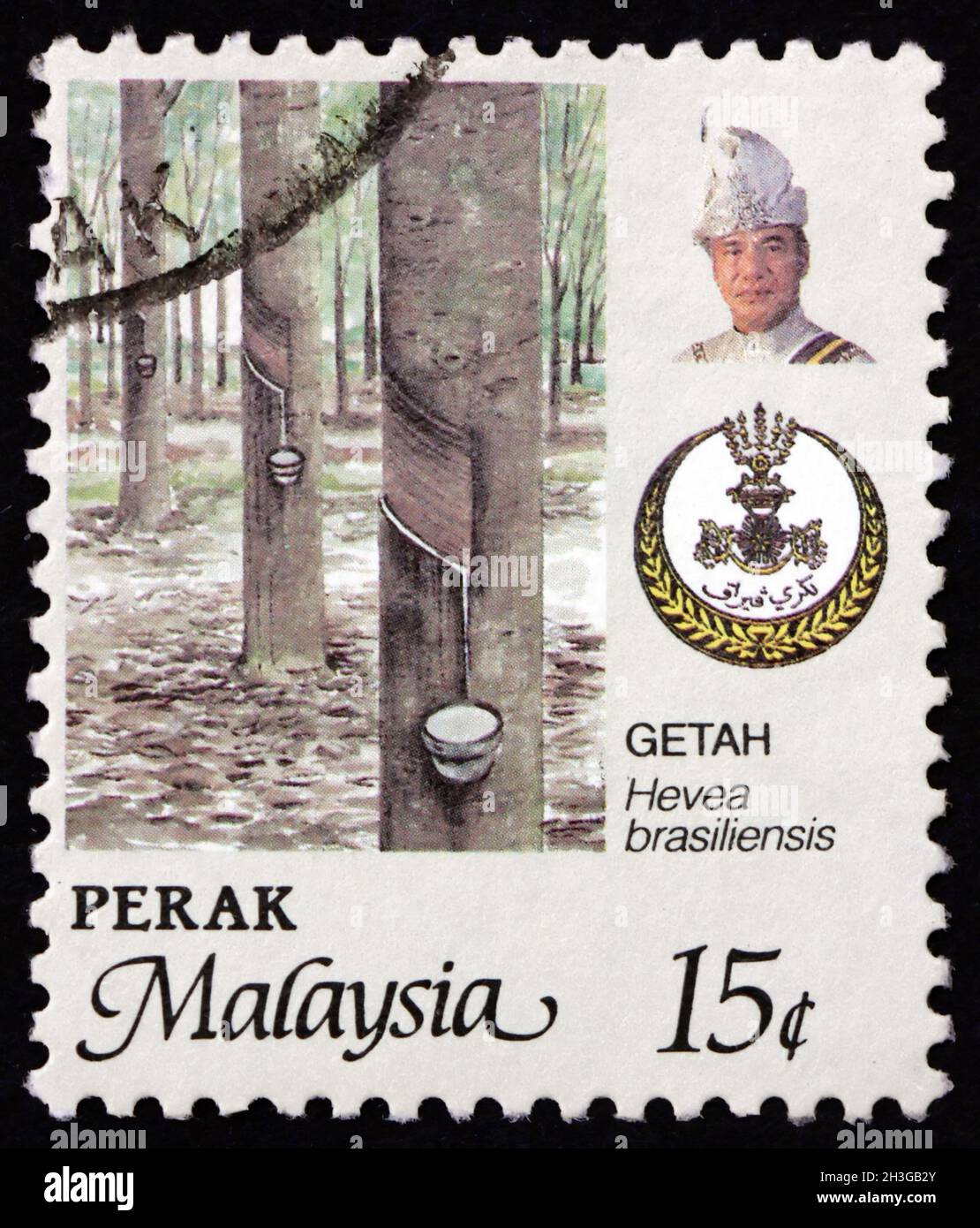 MALAYSIA - CIRCA 1986: a stamp printed in Malaysia shows rubber tree (hevea brasiliensis), state arms and Raja Tun Azian Shah, circa 1986 Stock Photo