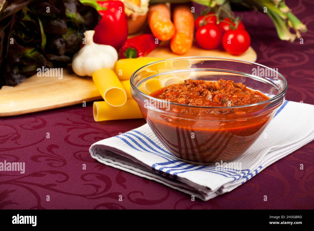 Bowl with Bolognese sauce and raw vegetables Stock Photo