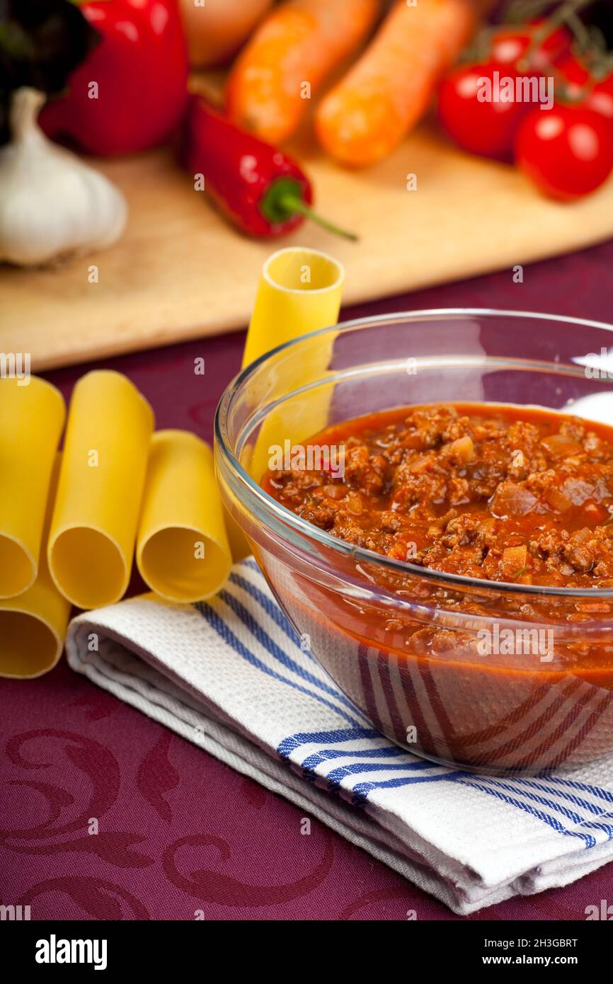 Bowl with Bolognese sauce and raw vegetables Stock Photo