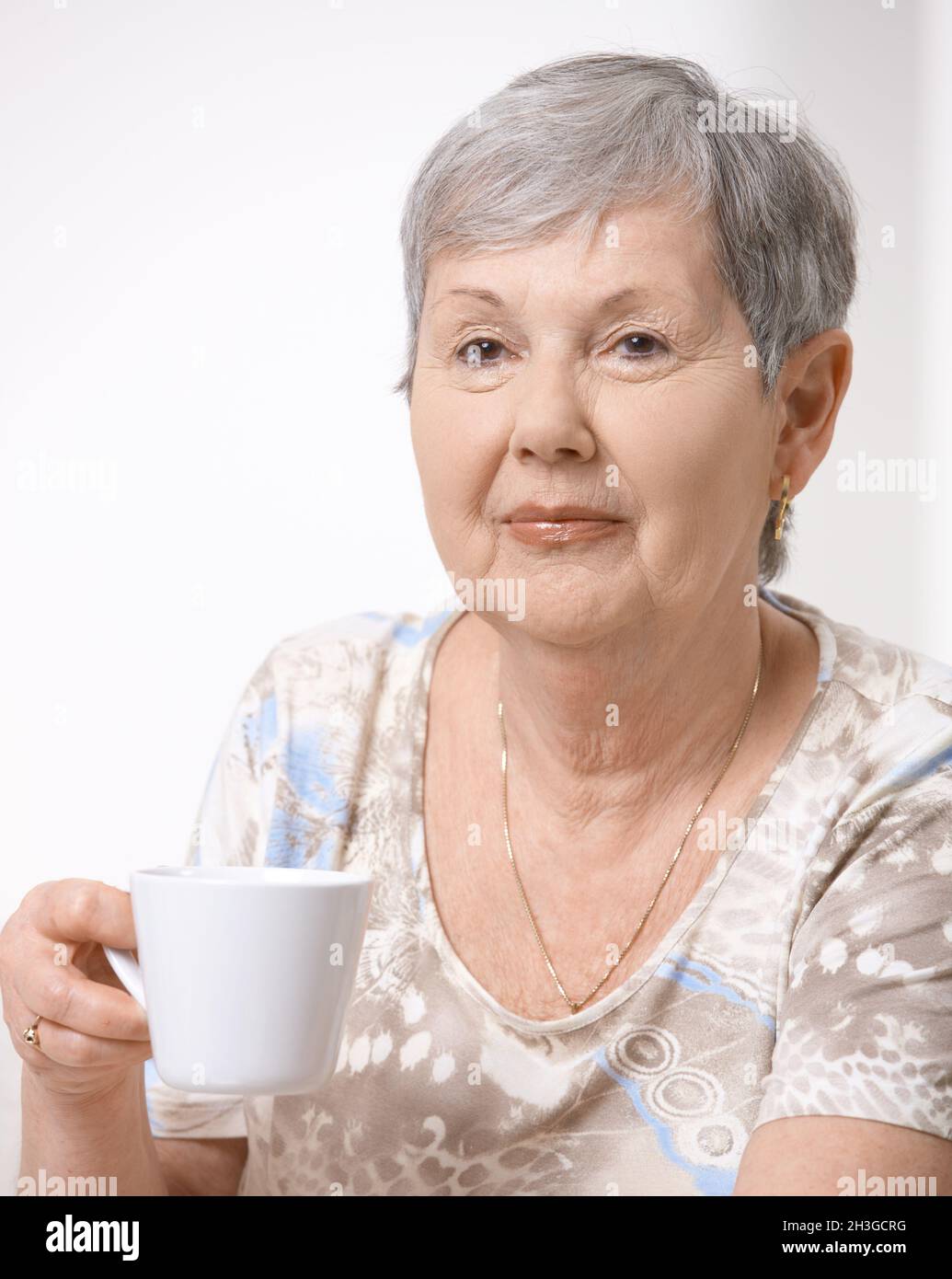 Mature woman drinking tea cosy hi-res stock photography and images - Alamy