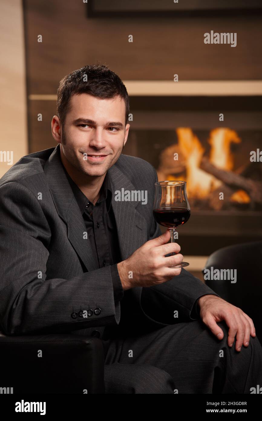Businessman drinking wine at home Stock Photo