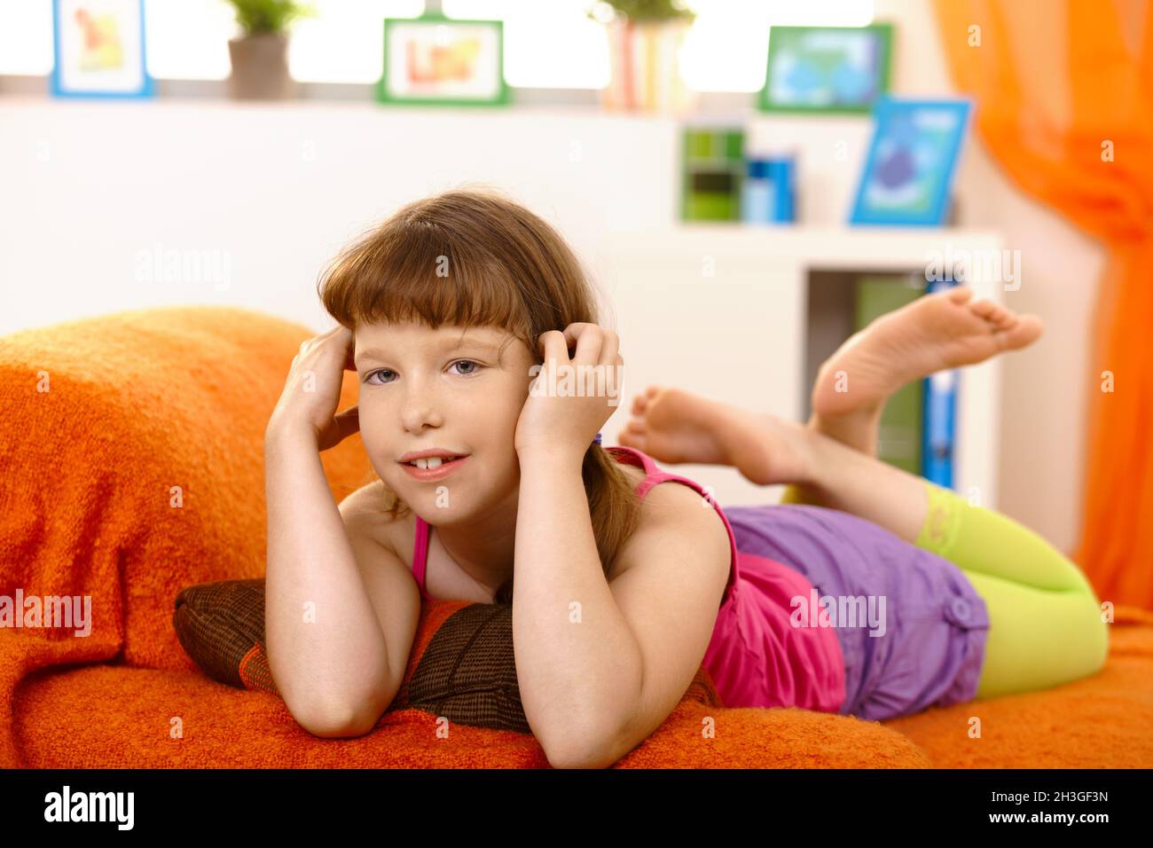 Little girl lying on sofa Stock Photo - Alamy