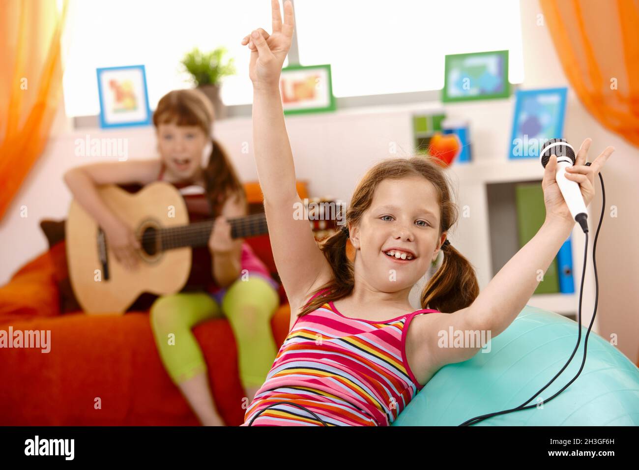 Small laughing girl with microphone Stock Photo