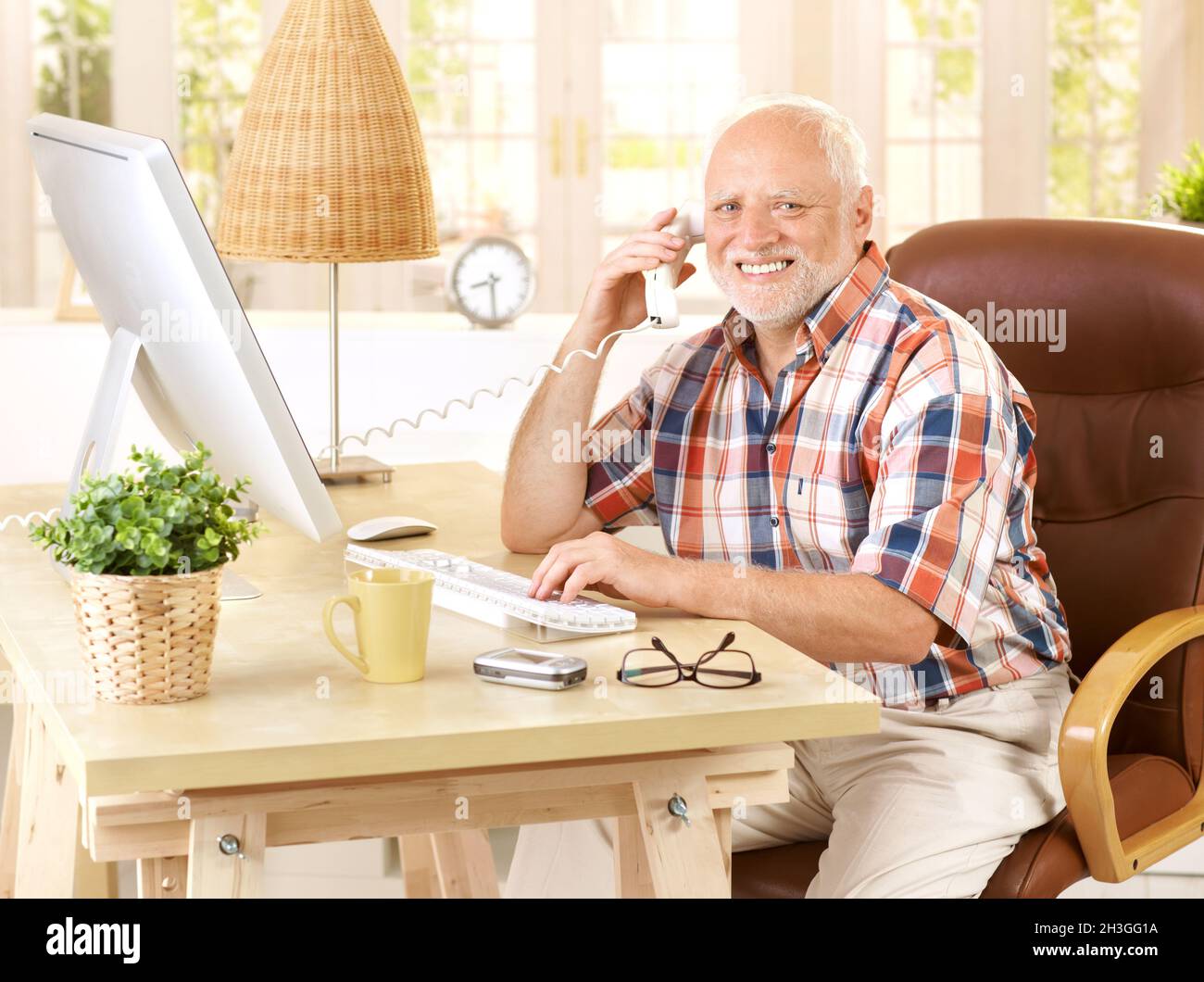 Happy old man on landline call Stock Photo