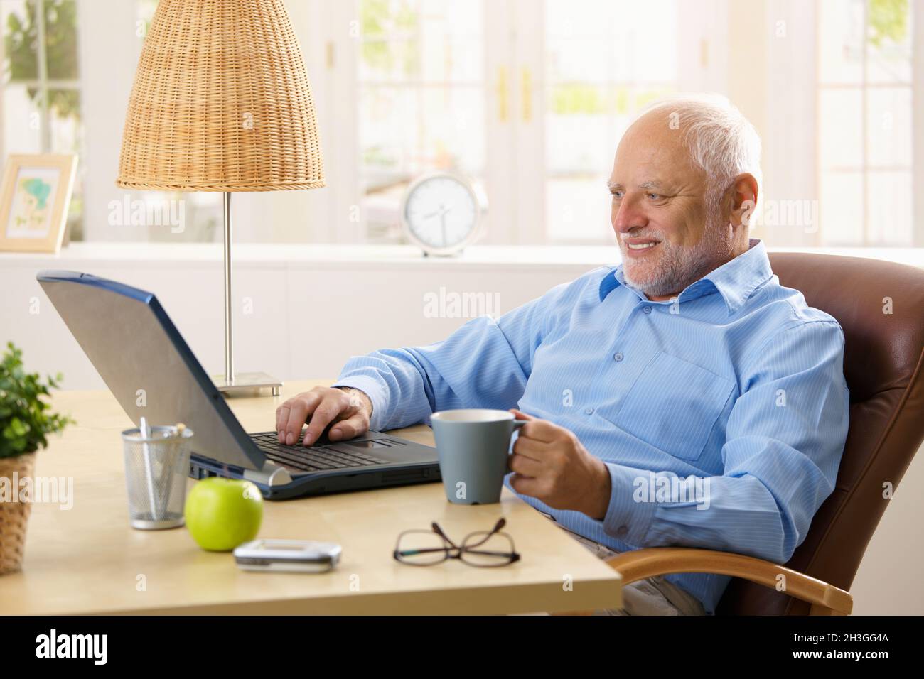 Smiling senior man using laptop Stock Photo