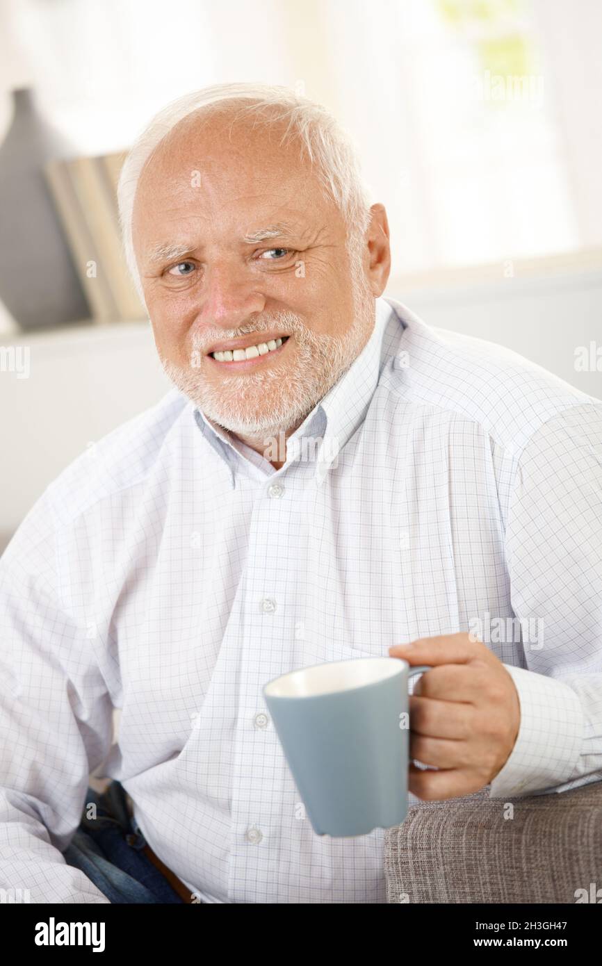 Smiling old man having coffee Stock Photo