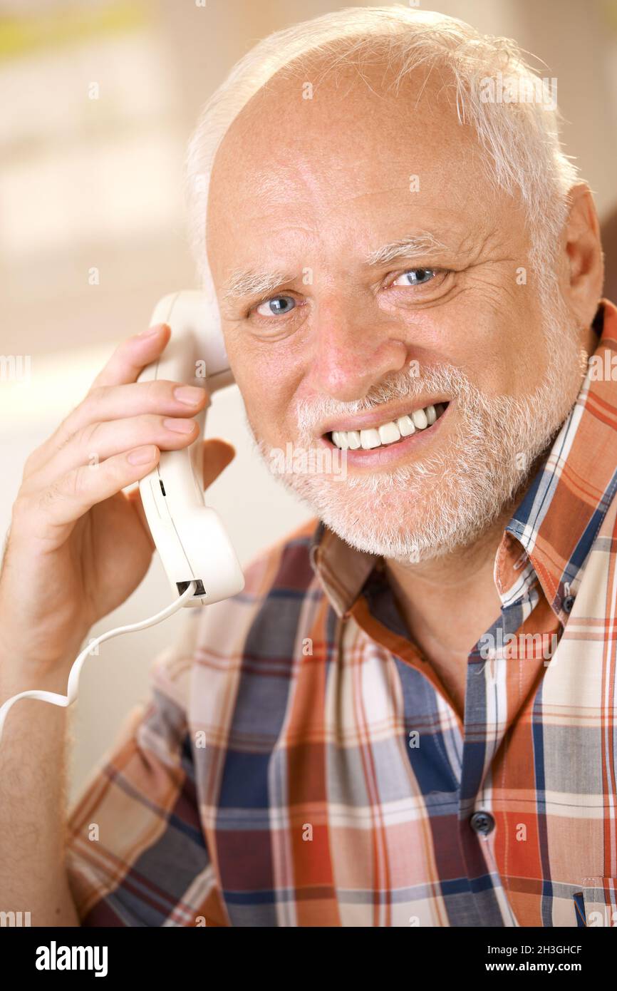 Older man on landline phone call Stock Photo
