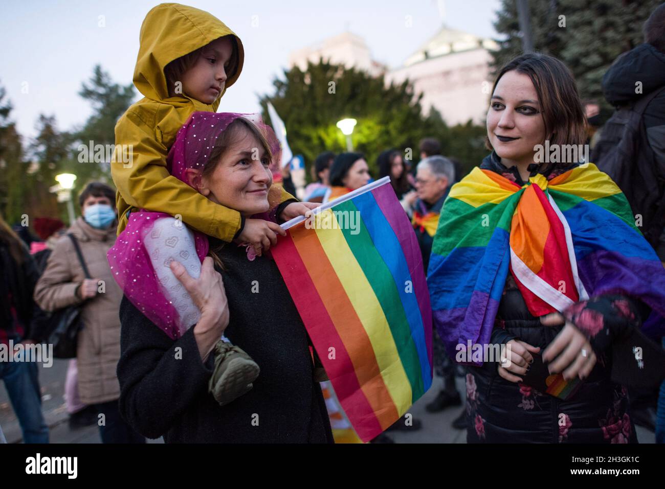 A protester with a kid on her back holding a rainbow flag is seen during the demonstration.People gathered outside the Polish Parliament in Warsaw to protest against a law proposal that would put a total ban on equality marches. If the so called “Stop LGBT” bill is passed, prides and equality marches will be banned, as well as any other public gatherings that “promote” non-heterosexual orientations and heterosexual gender identities. Today in the Parliament's lower house a discussion was held on this project, and a vote is scheduled for 29th of October. 'Stop LGBT' is a civic bill for which si Stock Photo