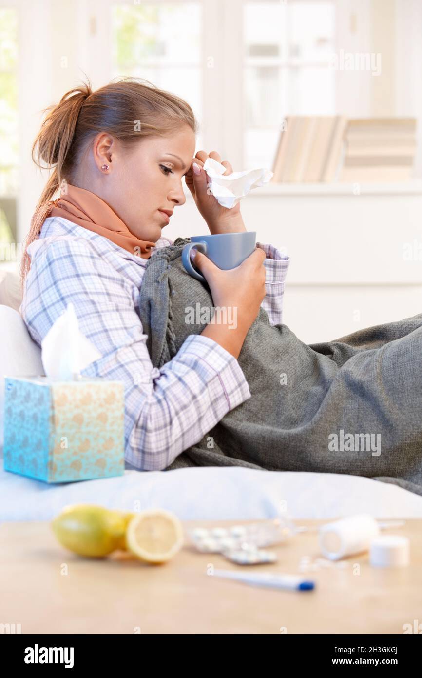 Young woman caught cold curing herself at home Stock Photo