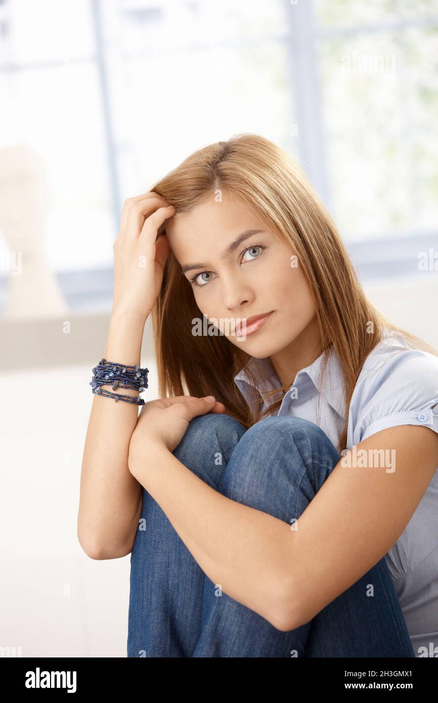 Attractive woman sitting on floor hugging knees Stock Photo - Alamy