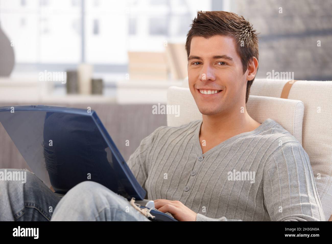 Portrait of cheerful young man using computer Stock Photo