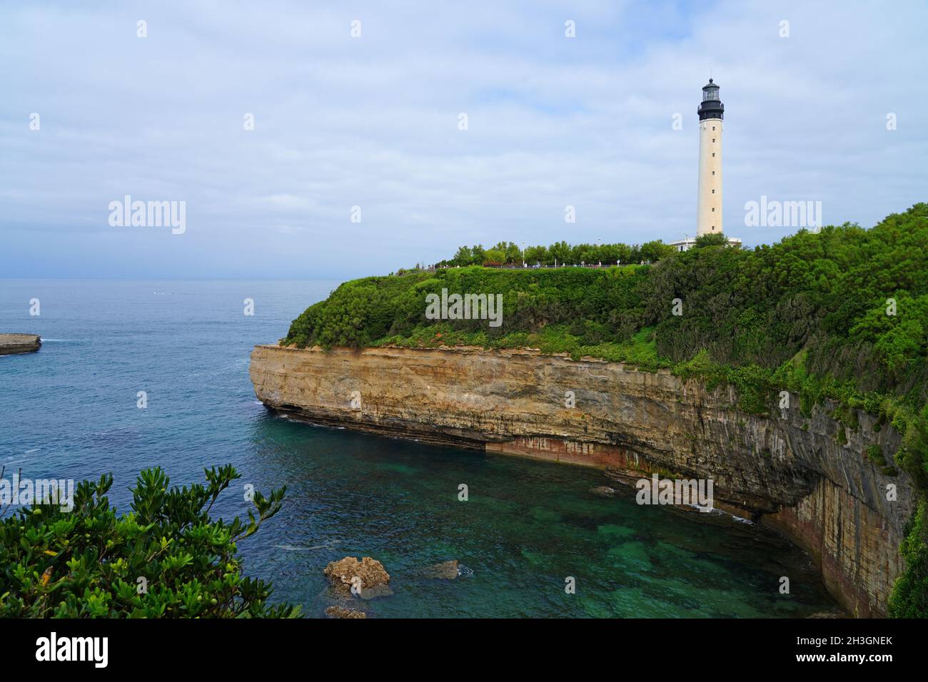 Basque Lighthouse View of the landmark Phare de Biarritz lighthouse on a rocky cliff in ...