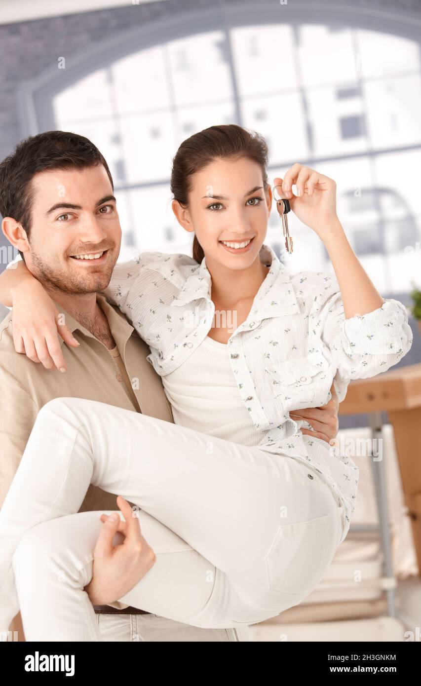 Happy couple moving to new home smiling Stock Photo - Alamy