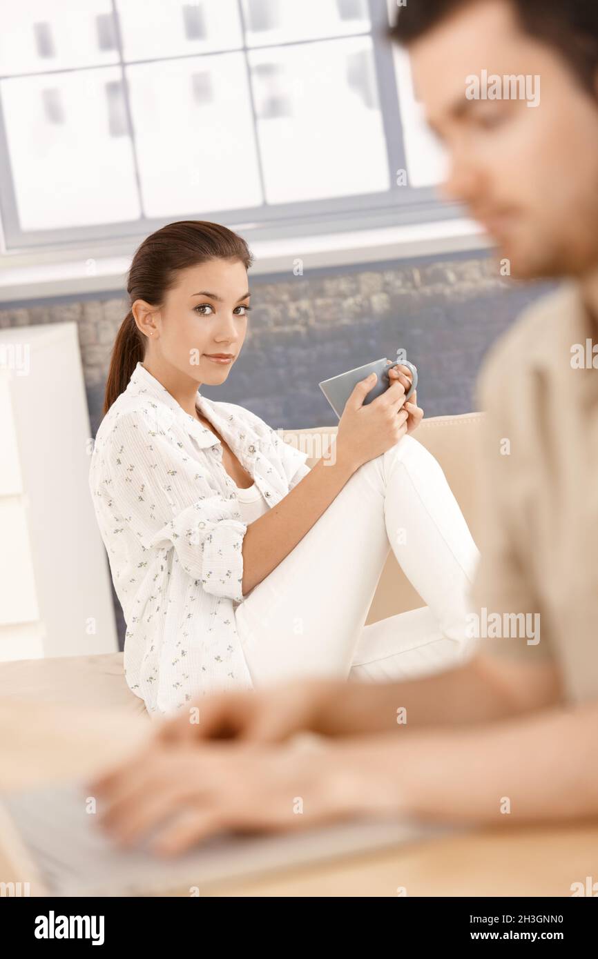 Young woman sitting bored man working on laptop Stock Photo