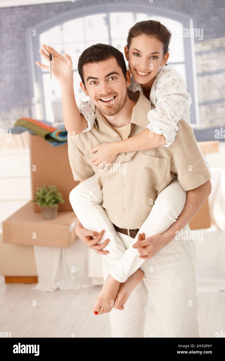 Happy couple celebrating new home smiling Stock Photo - Alamy