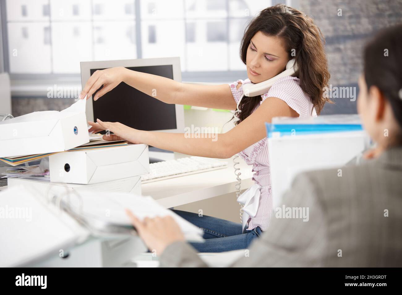 Young office worker on phone busy Stock Photo