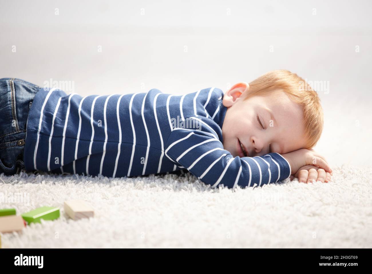 3 year old falling asleep on floor at home Stock Photo Alamy