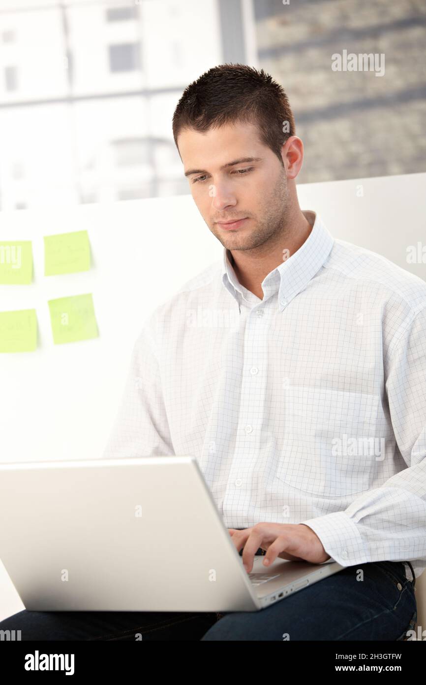 Casual office worker using laptop Stock Photo