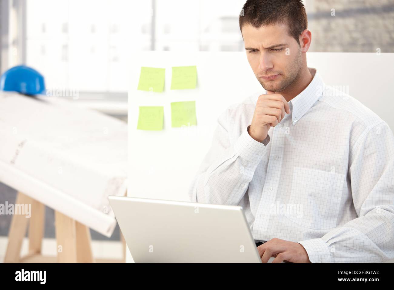 Young architect working on laptop Stock Photo