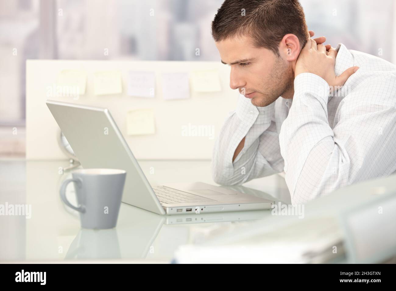 Young man looking tired in office Stock Photo