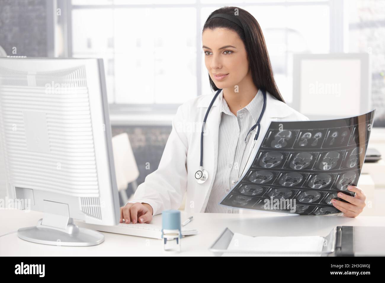 Smiling doctor working at desk Stock Photo
