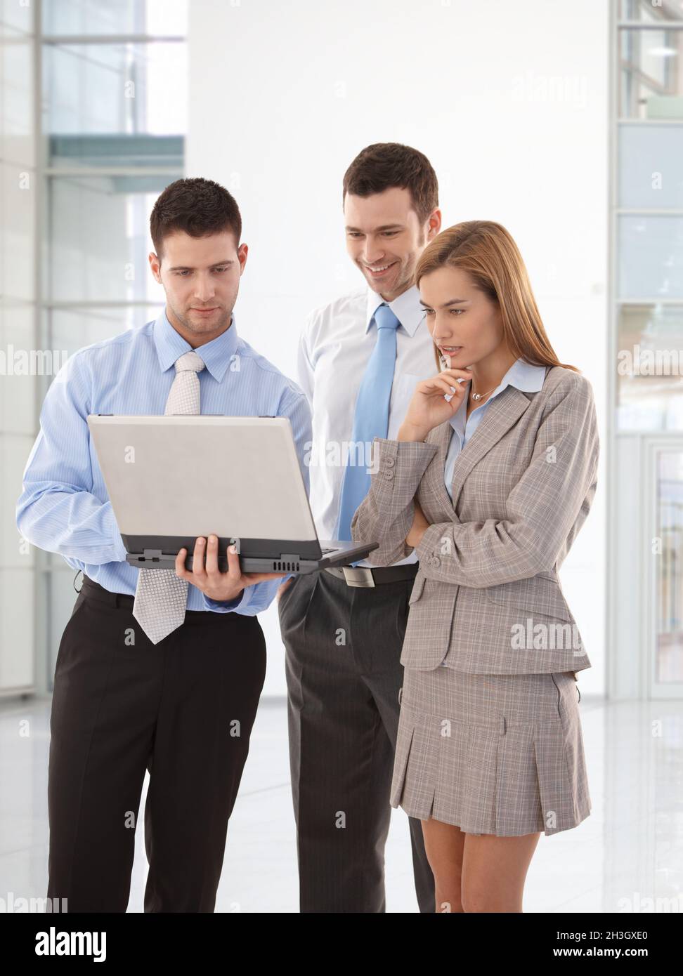Young businesspeople looking at laptop screen Stock Photo