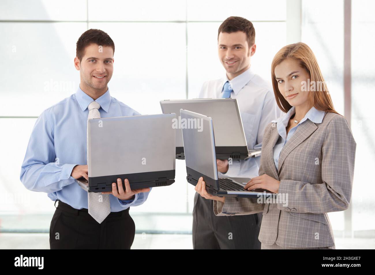 Confident businessteam working on laptop smiling Stock Photo