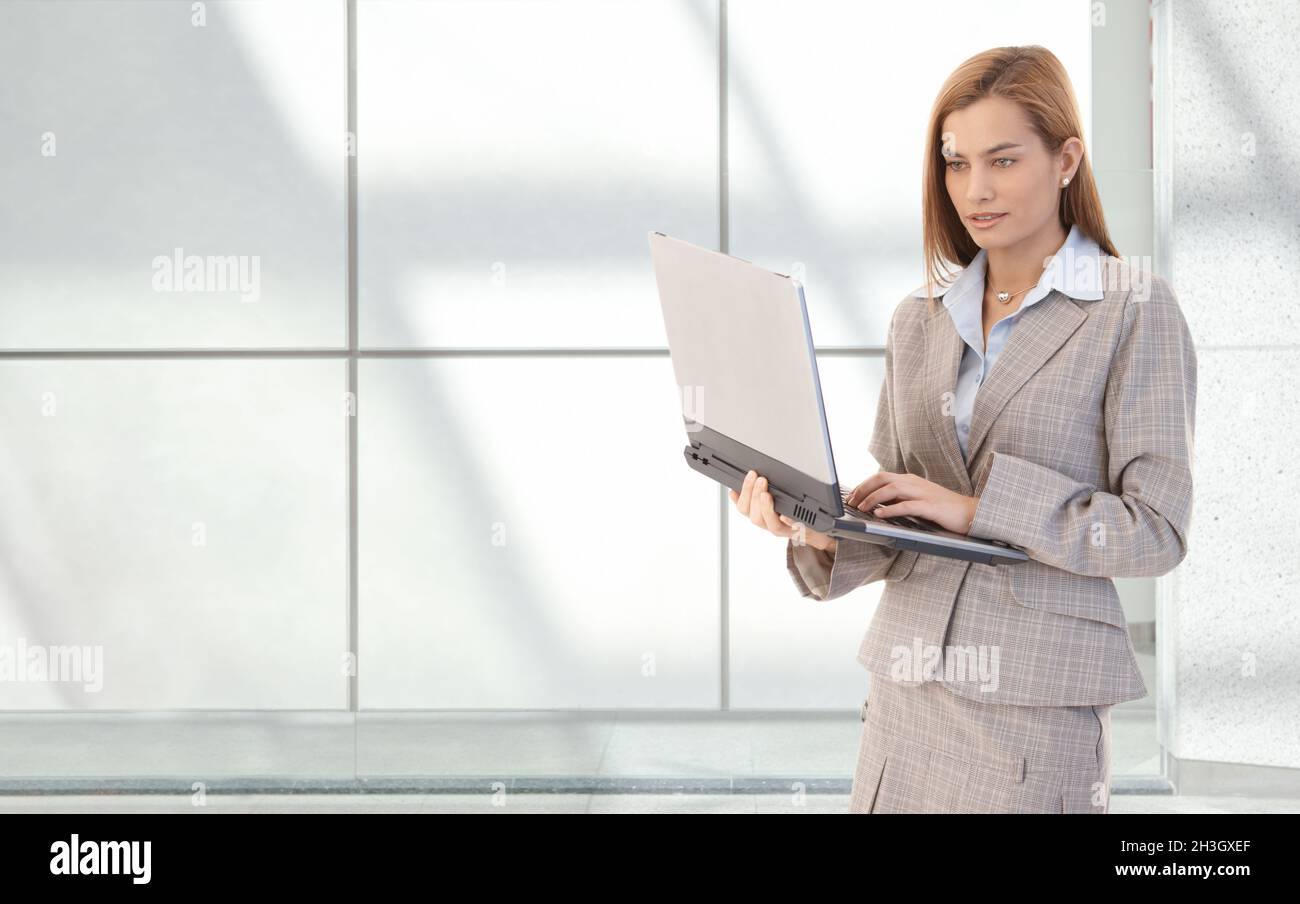 Attractive businesswoman with laptop in hands Stock Photo