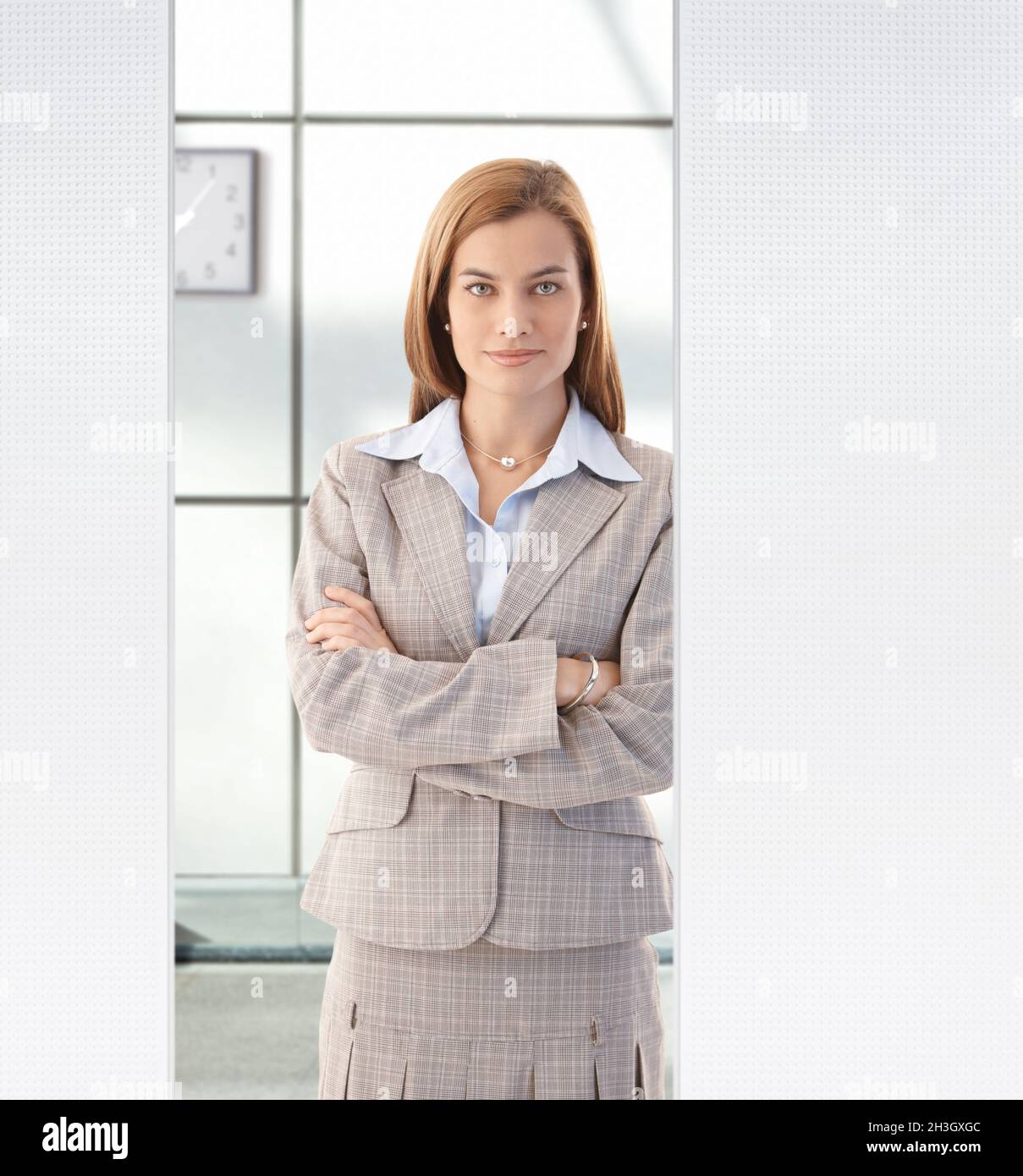 Pretty businesswoman standing in office smiling Stock Photo