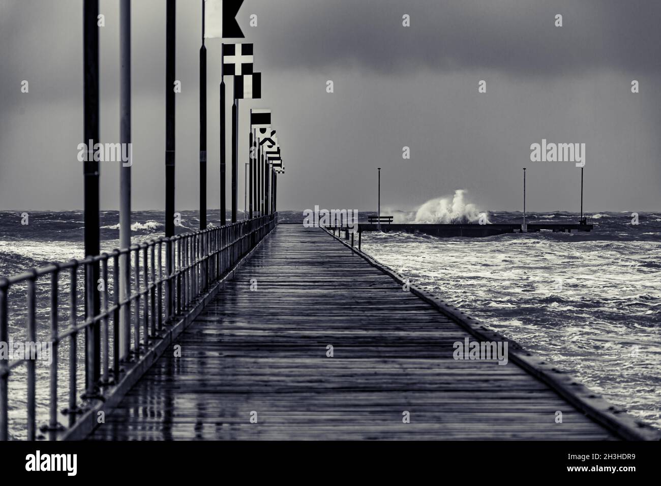 Moody Frankston Pier with Waves Crashing in windy Storm Stock Photo