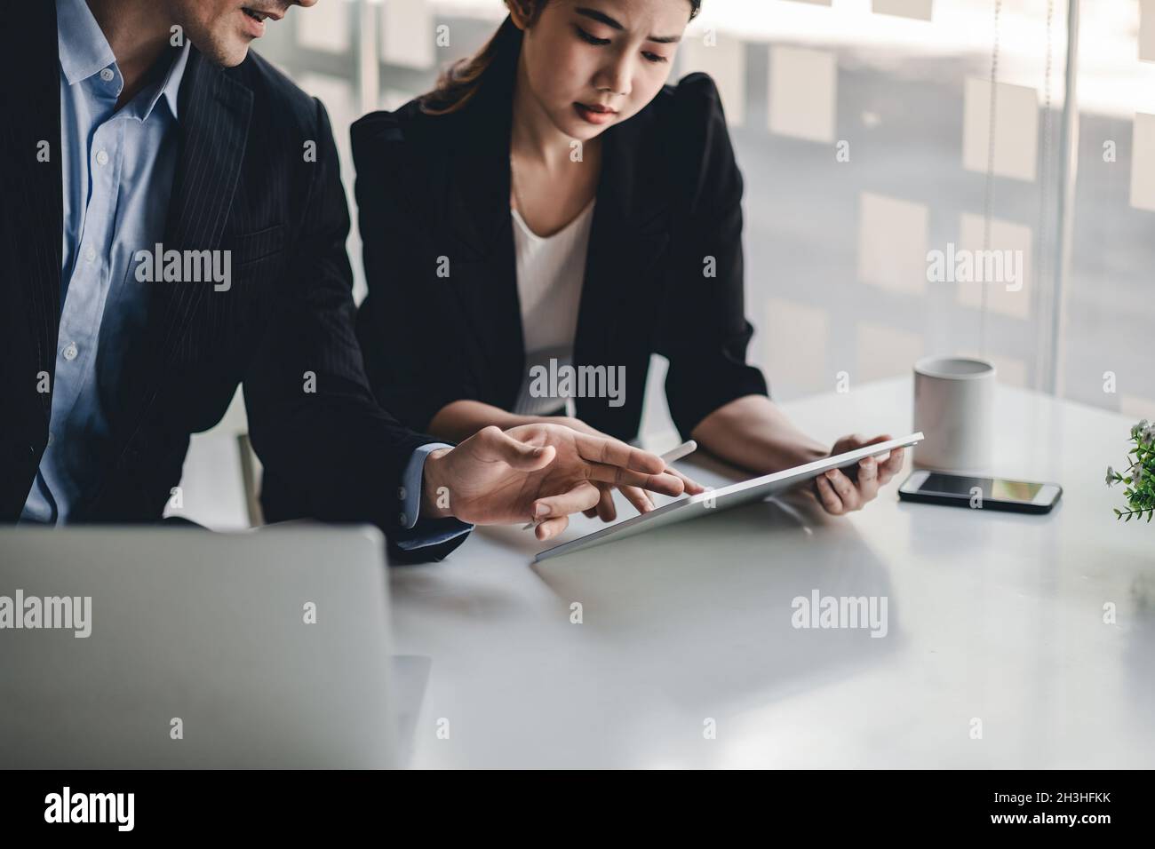 Diverse business people working together with digital tablet in office meeting room, colleague discussion about project work Stock Photo