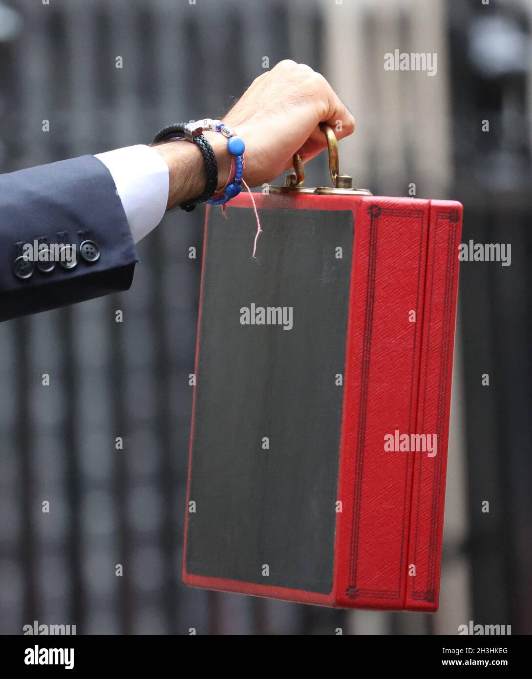 London, UK. 27th Oct, 2021. A LOVE charm on the bracelet of Rishi Sunak the Chancellor of the Exchequer with the red Budget Box outside Number 11 Downing Street before he delivers his Budget speech in The House of Commons at lunchtime. Budget Day, Downing Street, Westminster, London, October 27, 2021. Credit: Paul Marriott/Alamy Live News Stock Photo
