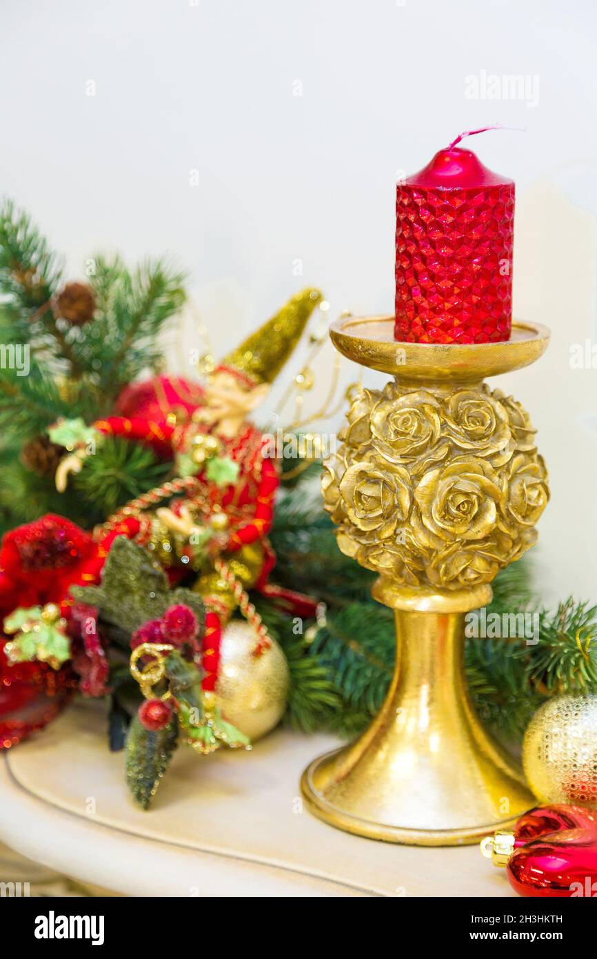 A fireplace mantle is decorated for Christmas with garland, lights, a bow and other decorations. Stock Photo