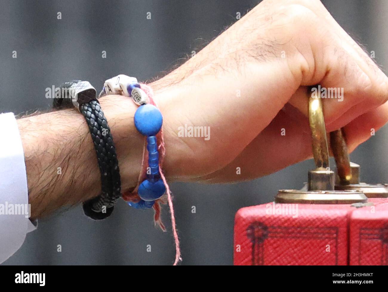 London, UK. 27th Oct, 2021. A love charm on the bracelet of Rishi Sunak the Chancellor of the Exchequer with the red Budget Box outside Number 11 Downing Street before he delivers his Budget speech in The House of Commons at lunchtime. Budget Day, Downing Street, Westminster, London, October 27, 2021. Credit: Paul Marriott/Alamy Live News Stock Photo