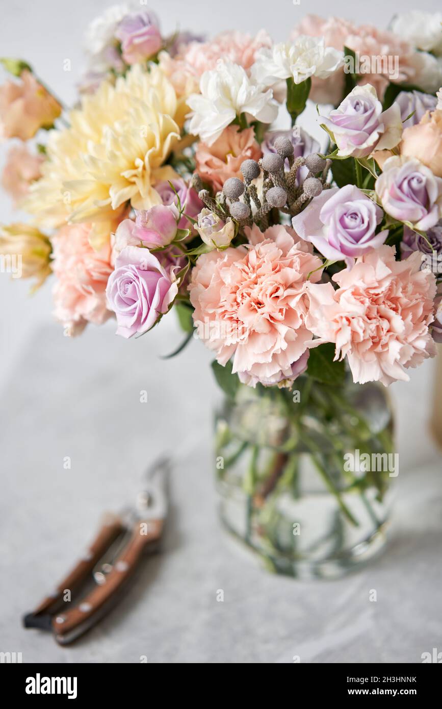 Finished flower arrangement in a vase for home. Flowers bunch, set for interior. Fresh cut flowers for decoration home. European floral shop. Delivery Stock Photo