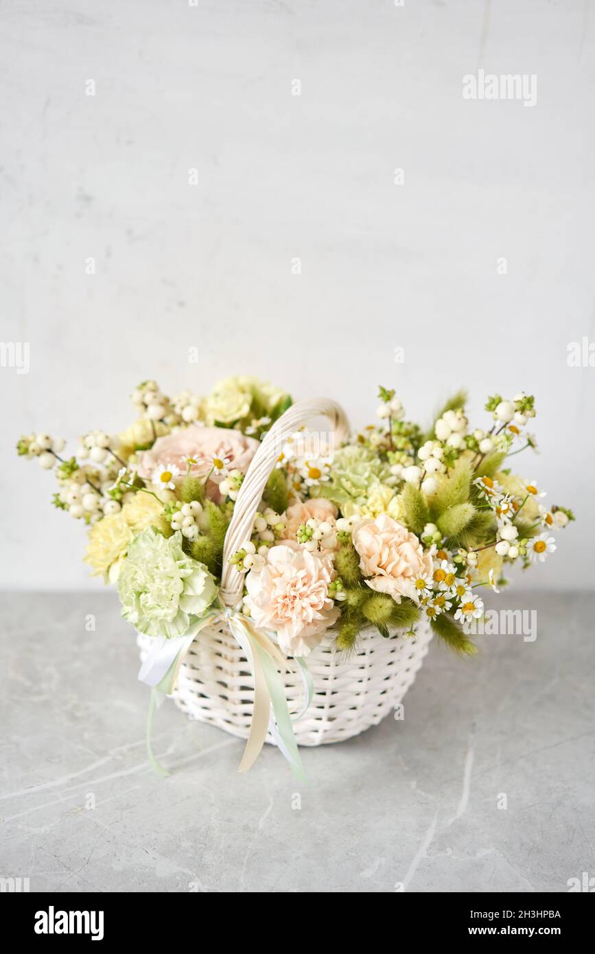 Flower arrangement in Wicker basket. Beautiful bouquet of mixed flowers. Handsome fresh bouquet. Small flower shop and Flowers delivery. Stock Photo