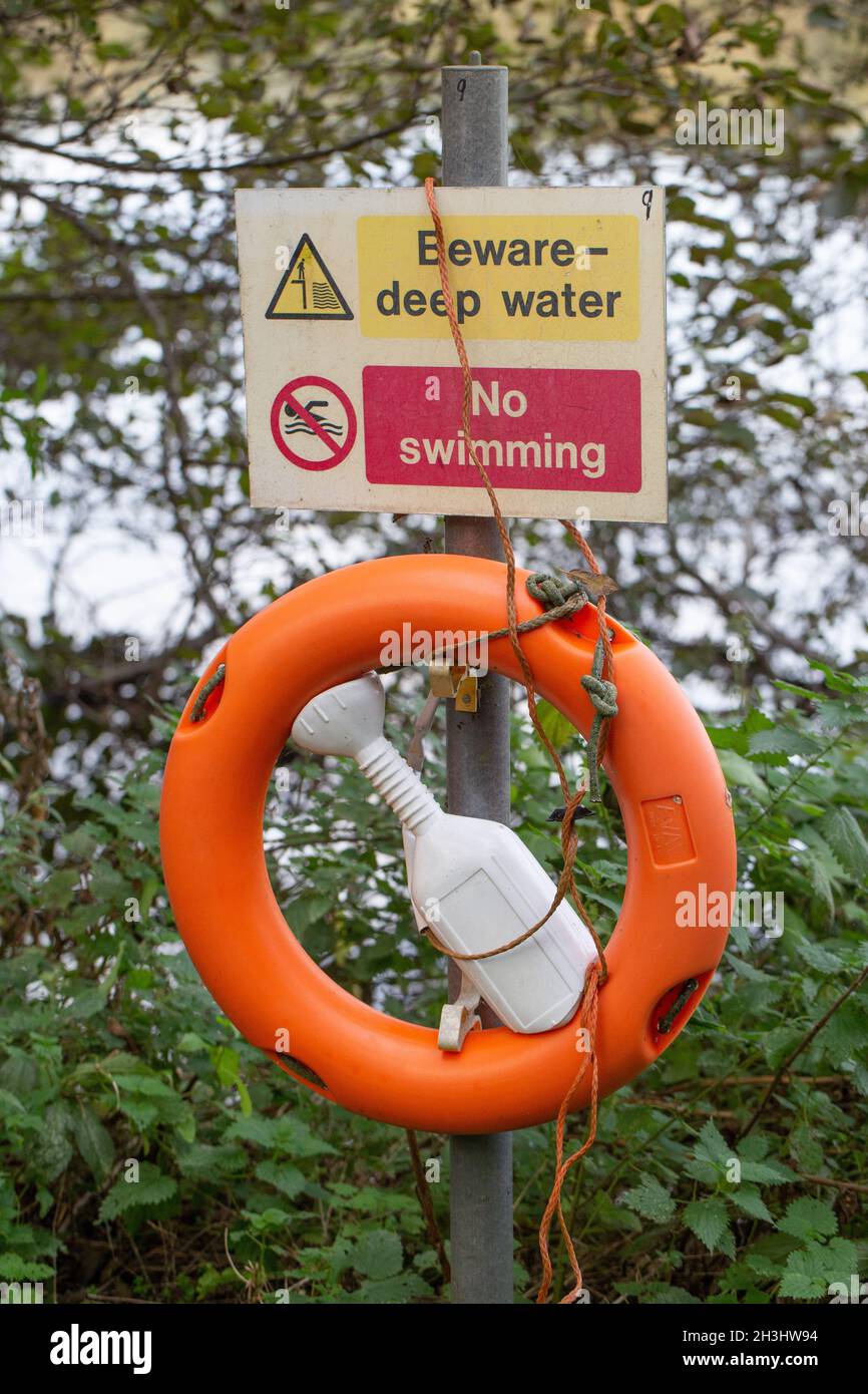 Health and Safety sign. Witlingham Park, Norwich. Beware-deep water. No Swimming. Alongside unfenced lake with public access. Cautionary warning risk Stock Photo