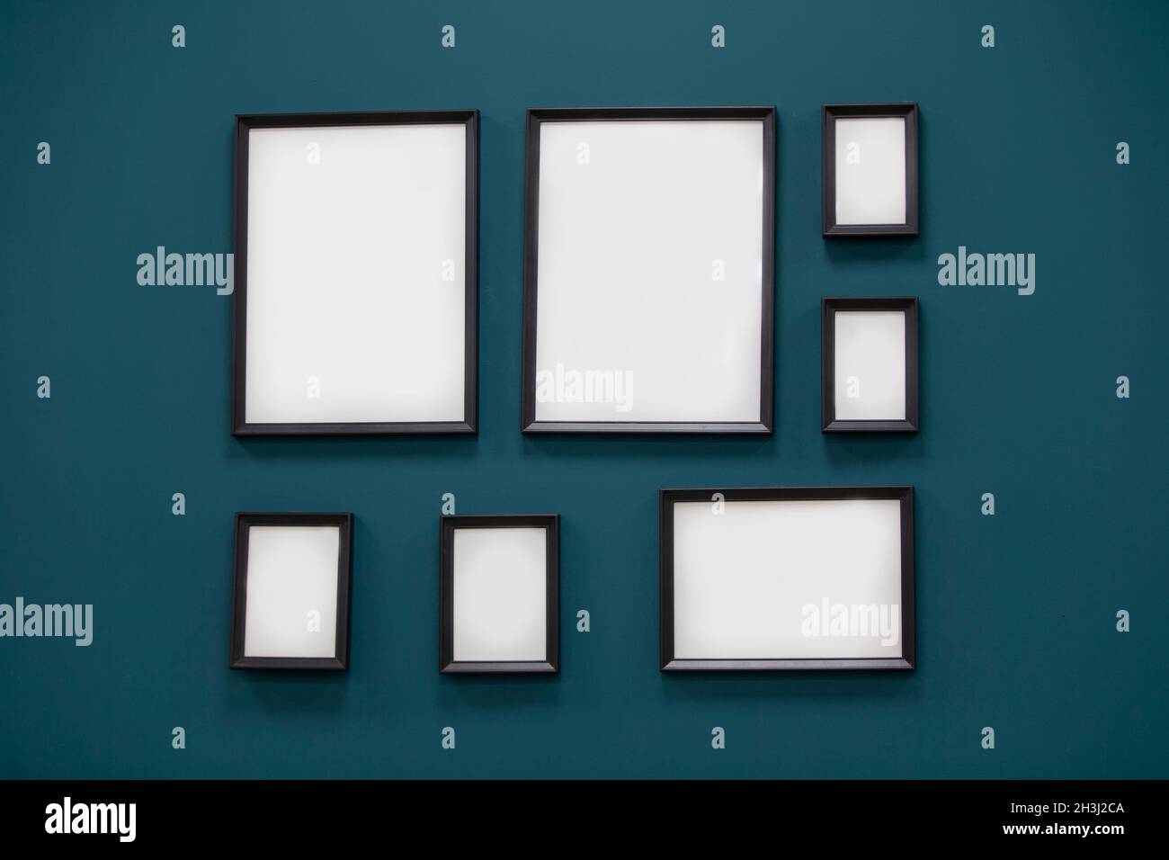 Frames without paintings on the wall. Picture frames on the green wall