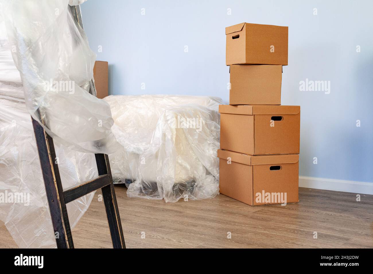 Packed household stuff in boxes and packed sofa for moving Stock Photo