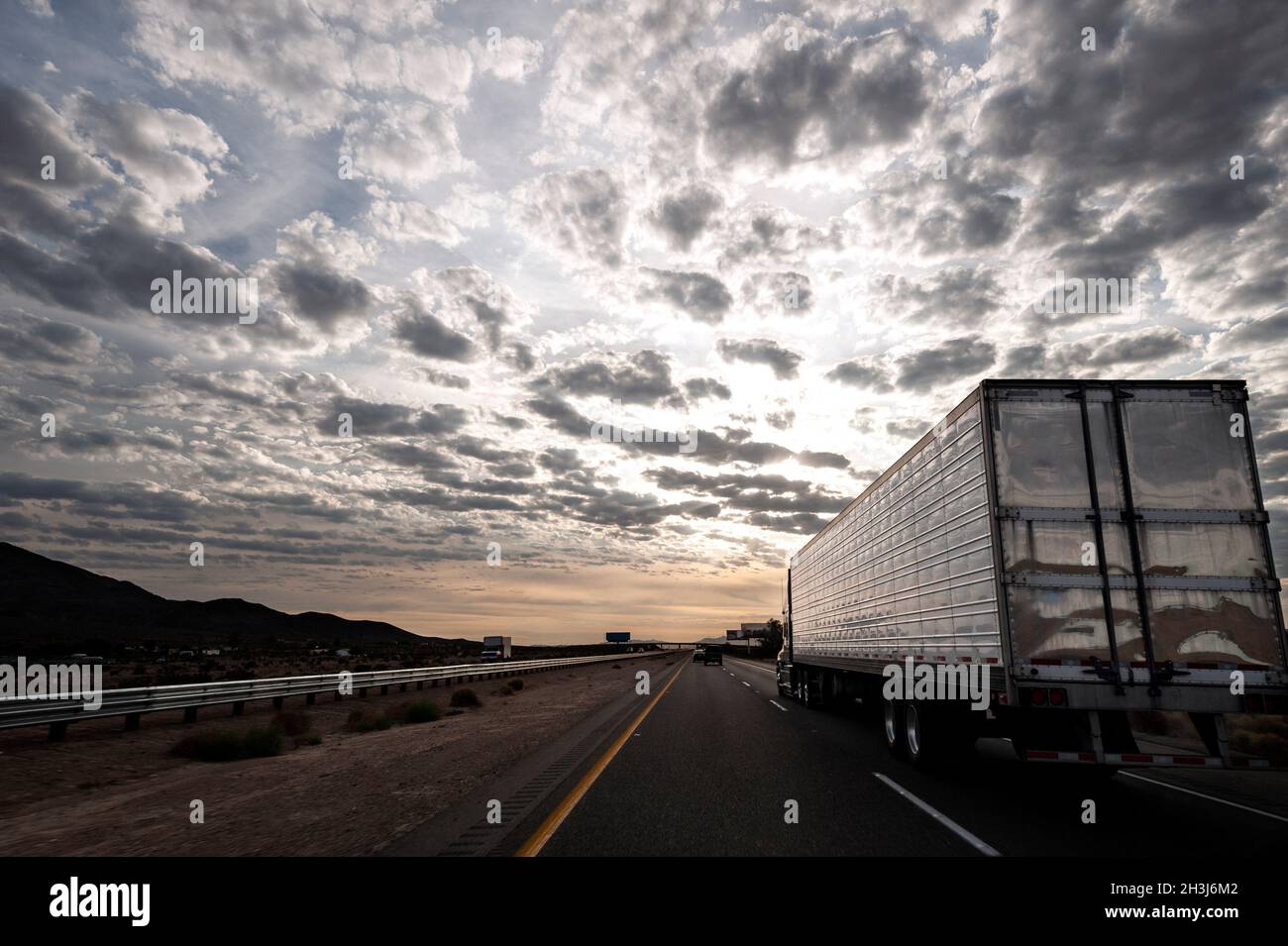Semi truck pulling a trailer full of cargo up a grade near Stateline