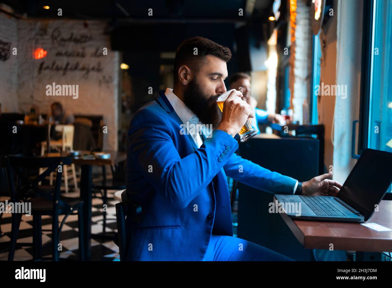A businessman with a laptop drinking beer in a pub Stock Photo