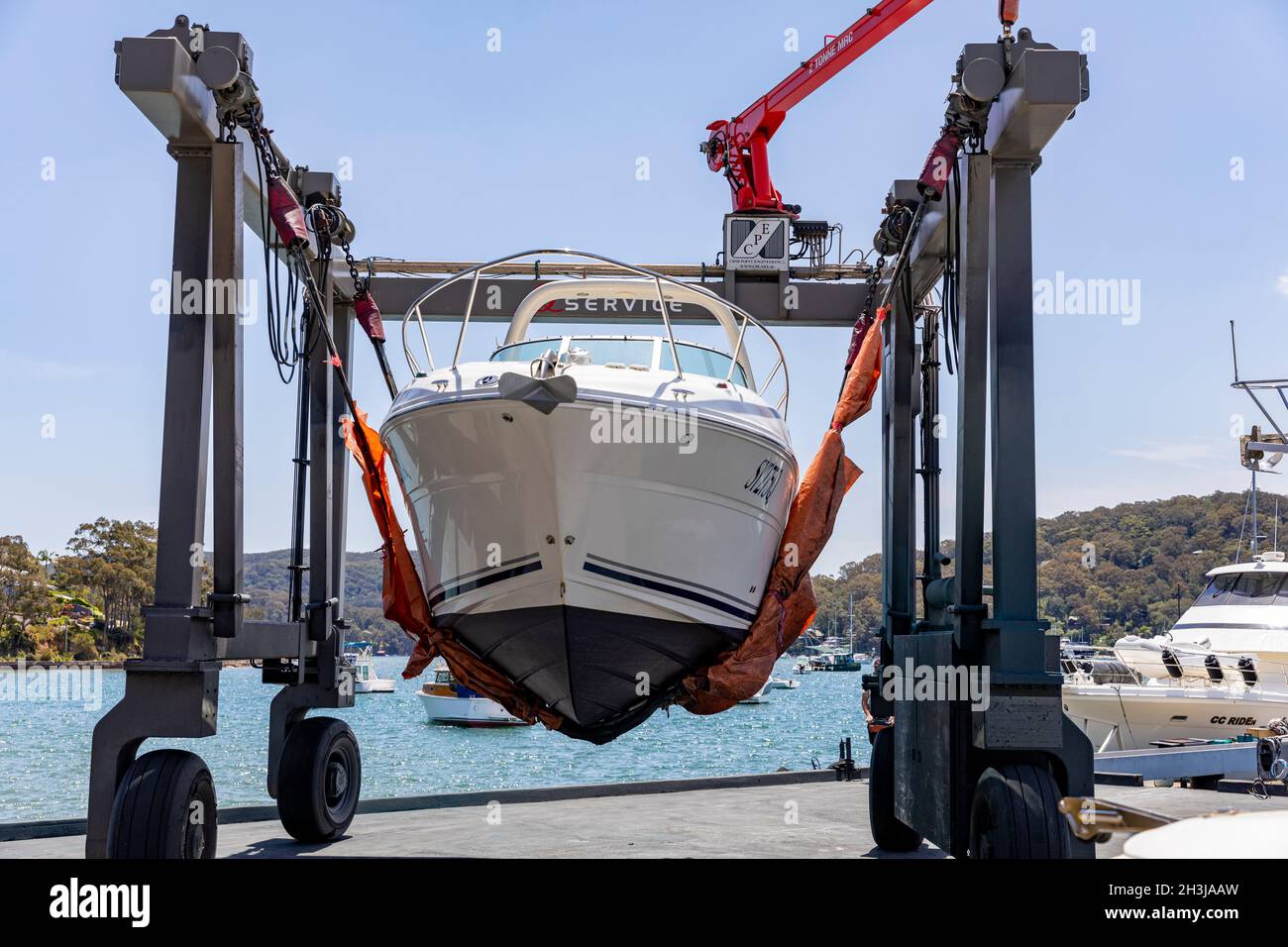Sea Ray Sundancer cruiser boat being lifted into the water by a marina crane hoist at Church